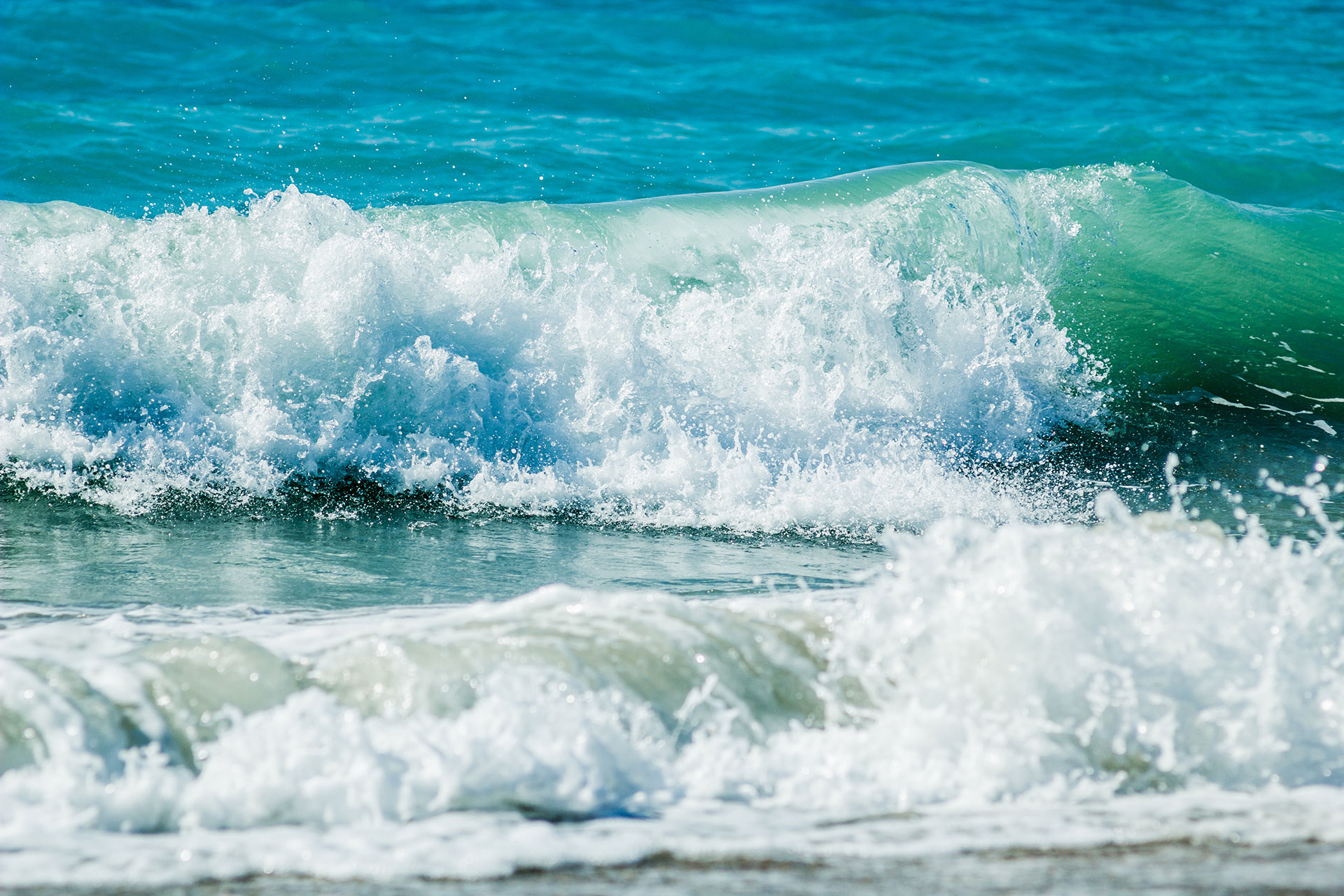 The image displays an ocean scene with a large wave approaching the shore, captured in two different photographs side by side, showcasing the dynamic nature of the sea.