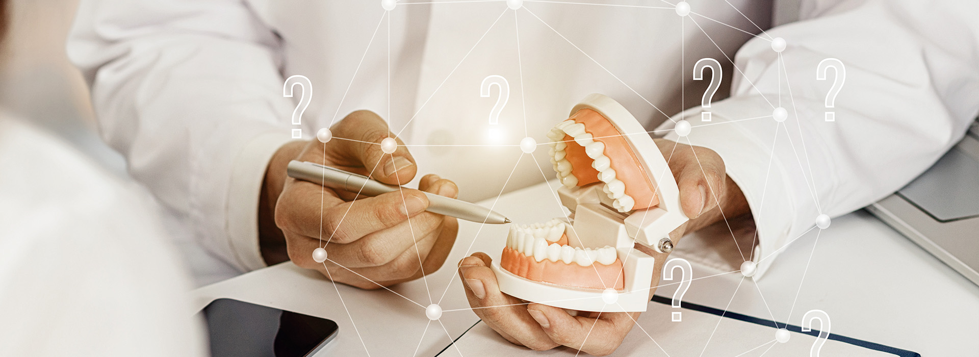 The image depicts a person s hand holding a dental model, with a digital interface displaying teeth and numbers overlaid on the model.