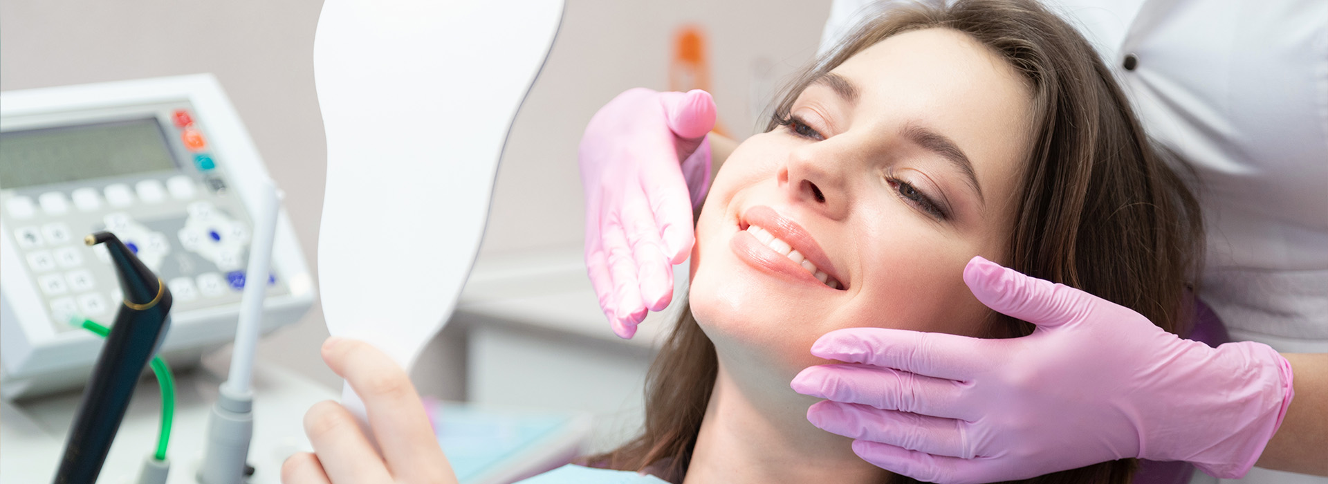 A woman in a dental chair receiving dental treatment with a smiling expression.