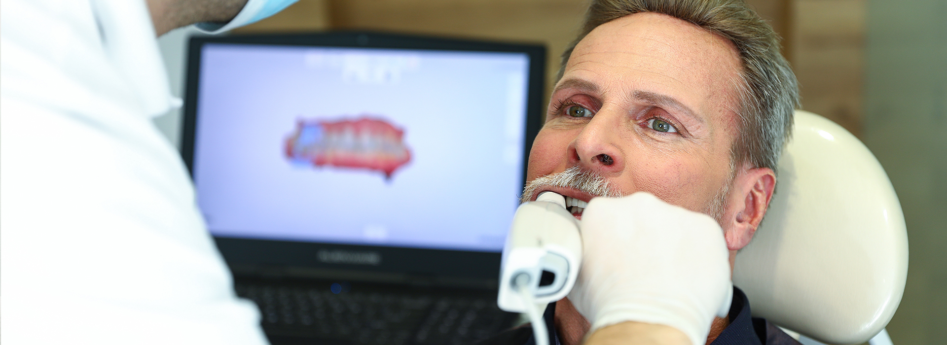 A man receiving dental care, with a dentist performing the procedure.