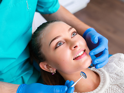 A woman receiving dental care from a professional in a dental office setting.